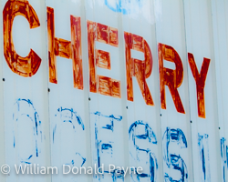 A processing warehouse sign has faded in the same sun and rain that nurtured the tons of cherries delivered through its doors.