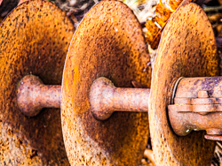 Three well-worn disks sit waiting for one last chance to work their magic in the fields.