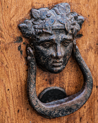 A mythic metallic face greets visitors to this Italian home.