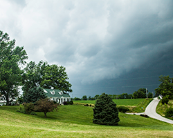 An imminent thunderstorm darkens over a Kentucky farm.